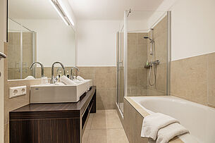 Badezimmer mit Dusche und Badewanne im Junior Apartment